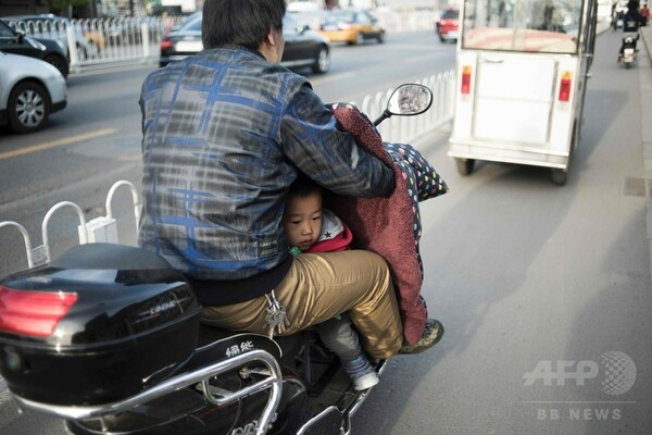 運転手の股の間から覗く子ども、北京