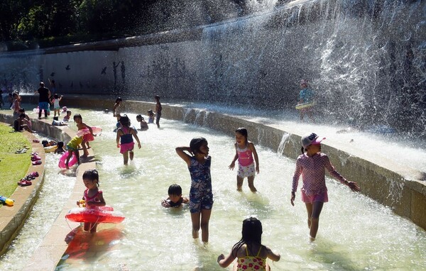 東京で35度の猛暑日、噴水で遊ぶ子どもたち