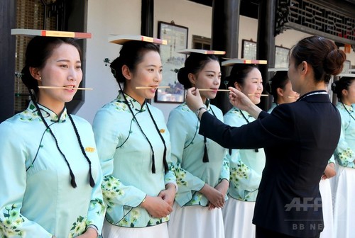 頭上に本、口に箸、手にはトランプ…中国観光ガイドのマナー講習 頭上に本、口に箸、手にはトランプ…中国観光ガイドのマナー講習