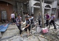 パレスチナ自治区ガザ地区（Gaza Strip）南部ラファ（Rafah）の難民キャンプ近くで発見された子どもの遺体を回収する医療従事者（2014年8月4日撮影）。(c)AFP/MAHMUD HAMS 