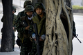 タイの首都バンコク（Bangkok）で木陰で警戒するタイ軍兵士（2010年5月15日撮影）。(c)AFP/Nicolas ASFOURI