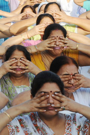 数百人でヨガ、インドの色あせない伝統