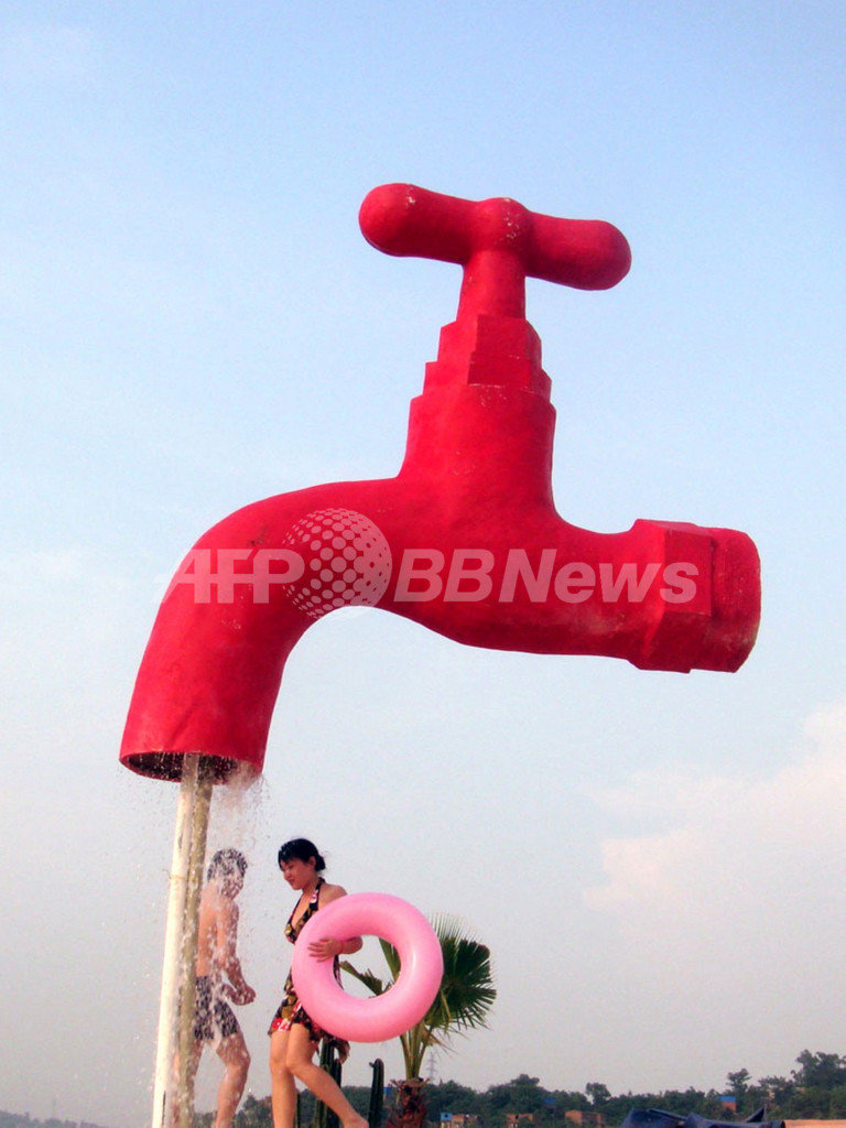 巨大な蛇口の下で水浴び、中国・重慶