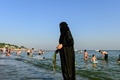 トルコ・イスタンブールのビーチに立つシリア人女性（2017年7月2日撮影）。(c)AFP/YASIN AKGUL