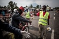 コンゴ民主共和国のゴマに続く道路に設置されたエボラ出血熱検査所で、手を洗浄するバイクの運転手（2019年7月16日撮影、資料写真）。(c)JOHN WESSELS / AFP 