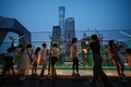 中国北京中心部のビジネス街で夜景を見る人々（2024年7月11日撮影）。(c) GREG BAKER / AFP