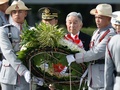 フィリピンの首都マニラで、無名戦士の墓にささげる花輪を持つフィリピン人兵士の後ろを進まれる天皇、皇后両陛下（2016年1月27日撮影）。(c)AFP/TED ALJIBE