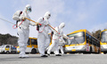 韓国・光州のバス車庫で消毒作業をする政府当局者ら（2020年3月3日撮影）。(c)YONHAP / AFP
