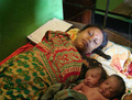 バングラデシュ・ジョソール（Jessore）にある病院で、母親のそばで眠る赤ちゃん（2008年8月26日撮影）。(c)AFP