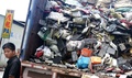 中国・広東省南部汕頭市の貴嶼で、トラックから電気機器の廃棄物を降ろす作業員（2014年8月9日撮影）。(c)AFP PHOTO / JOHANNES EISELE