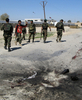 写真は13日、アフガニスタン南部のヘルマンド州の自爆攻撃現場で警戒にあたる国軍兵士ら。(c)AFP/Abdul Malek