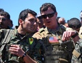 シリア北東部マリキヤで、クルド人民兵組織「クルド人民防衛部隊（YPG）」の戦闘員と話す米軍人（2017年4月25日撮影、資料写真）。(c)DELIL SOULEIMAN / AFP