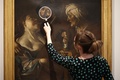 英ロンドンのコートールド美術館の「Art and Artifice: Fakes from the Collection（アートと策略：コレクションの贋作）」展で贋作者ハン・ファン・メーヘレンが手掛け、ディルク・ファン・バビューレンの作品とうたわれていた作品を見る同館の職員（2023年6月16日撮影）。(c)HENRY NICHOLLS / AFP