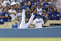 13MLBプレーオフ、ナ・リーグ地区シリーズ（5回戦制）、ロサンゼルス・ドジャース（Los Angeles Dodgers）対アトランタ・ブレーブス（Atlanta Braves）第3戦。邪飛を捕球し、スタンドに倒れ込むロサンゼルス・ドジャースのカール・クロフォード（Carl Crawford、2013年10月6日撮影）。(c)AFP/Getty Images/Stephen Dunn