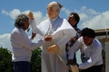 就任以来、初めて制作されたローマ・カトリック教会のフランシスコ（Francis）法王の像が、イタリア南部ナポリ（Naple
）近郊の小村チッチャーノ（Cicciano）のジャガイモ畑で20日、お披露目された。

法王の両親が同国北部ピエモンテ（Piedmont）州の出身で、多くのイタリア人たちと同様、2度の世界大戦の間にアルゼンチンに移住したことに敬意を表して作られたものだという。チッチャーノ出身の俳優、バルバート・デステファノ（Barbato De Stefano）さんが来月バチカン（Vatican）で、法王に献上する予定だ。

写真は、ジャガイモ畑に立つフランシス法王の像と衣服を直すデステファノさん（中央）と彫刻家のジュゼッペ・インペラトーレ（Giuseppe Imperatore）氏（左）ら（2013年5月20日撮影）。(c)AFP/MARIO LAPORTA