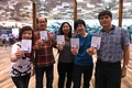 シンガポールのチャンギ国際空港で、記念グッズを手にポーズを取る「世界最長の直行便」の乗客（2018年10月11日撮影）。(c)ROSLAN RAHMAN / AFP