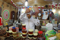 中東らしいバザールの情緒にあふれる、カタールの首都ドーハ（Doha）の目抜き通りスーク・ワキーフ（Souq Waqif）。蜂蜜売りの男性（2012年7月2日撮影）。(c)AFP
