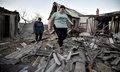 ウクライナ東部ドネツク州のロシア支配地域で、ロシア占領当局がウクライナ軍によるものと主張する砲撃で損壊したアパートの前を歩く住民（2024年4月6日撮影）。(c)STRINGER / AFP
