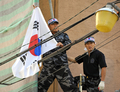 韓国・ソウル（Seoul）で、竹島問題で日本に抗議し日本大使館の壁によじ登り、韓国国旗を掲げる退役軍人（2008年7月17日撮影）。(c)AFP/KIM JAE-HWAN