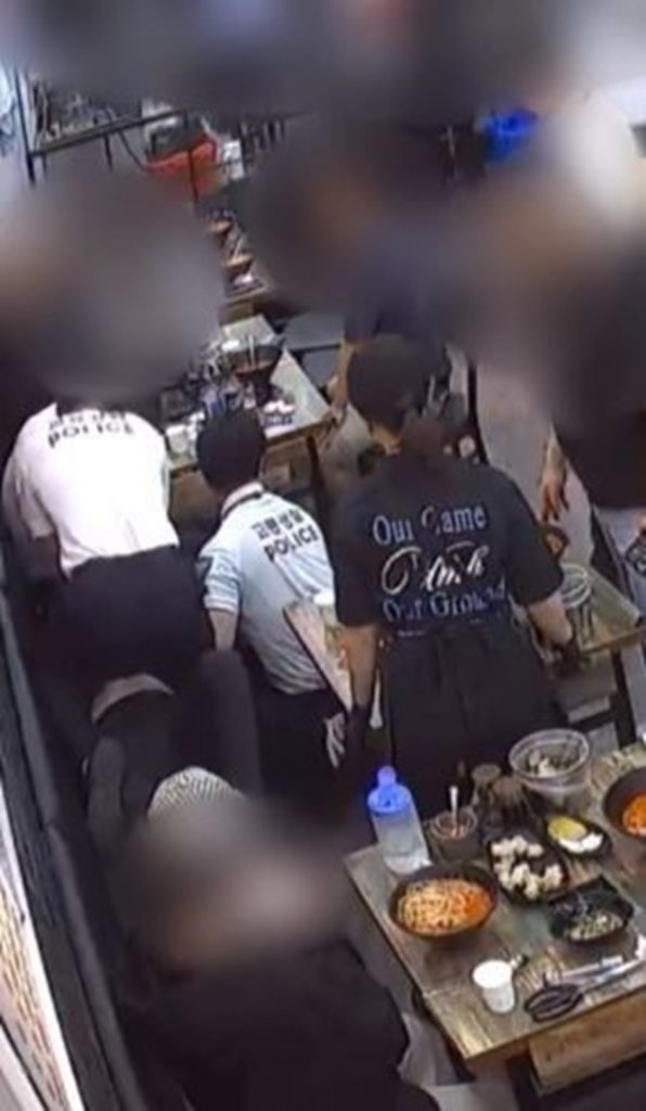食事中に倒れた客に応急処置を施す警察官ら＝オンライン掲示板「ボベドリーム」より(c)NEWSIS