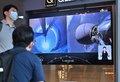 韓国初の月探査機を載せた宇宙開発企業スペースXの「ファルコン9」ロケットの打ち上げを報じるテレビ番組を見る人々。ソウルの鉄道駅にて（2022年8月5日撮影）。(c) Jung Yeon-je / AFP