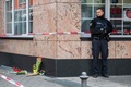 ドイツ西部ハーナウで起きた銃撃事件の現場に置かれたろうそくや花束のそばに立つ警察官（2020年2月20日撮影）。(c)Thomas Lohnes / AFP