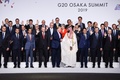 大阪で開催中の20か国・地域（G20）首脳会議の歓迎行事で、記念撮影に臨む参加国・国際機関の代表者（2019年6月28日撮影）。(c) Brendan Smialowski / AFP