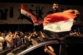 イラク・バグダッドのタハリール広場で、国旗を掲げて反政府デモに参加する人々（2019年10月24日撮影）。(c)AFP
