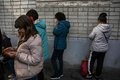 ウクライナ・イジュームの人道支援センター前で、携帯電話を使用する人々（2022年9月29日撮影）。(c)Juan BARRETO / AFP