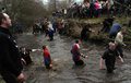 英イングランド中部ダービーシャー（Derbyshire）州アッシュボーン（Ashbourne）で21日から2日間、恒例のフットボール大会、｢ロイヤル・シュローブタイド・フットボール（Royal Shrovetide Football）｣が行われた。
　
　毎年、キリスト教「灰の水曜日（Ash Wednesday）」に行われる、このフットボール大会は、町全体をピッチに見立て、約5キロ離れたゴールを目指し、数千人の住民がひとつのボールを追いかけて町中を走り回る豪快なスポーツで、数世紀をさかのぼる伝統を持つ。

　アッシュボーンの住民たちは、街の真ん中を流れるヘンモア（Henmore）川を境に、｢アッパーズ（Up’ards、上手チーム）｣と｢ダウナーズ（Down’Ards、下手チーム）｣に別れて試合を行う。

　写真は、ボールを追いかける参加者たち（2012年2月21日撮影）。(c)AFP/PAUL ELLIS