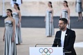 ギリシャ・アテネのパナシナイコ・スタジアムで行われたパリ五輪の聖火引継ぎ式で、スピーチをする大会組織委員会のトニー・エスタンゲ会長（右、2024年4月26日撮影）。(c)Aris MESSINIS / AFP