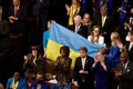 米連邦議会で、ウクライナ国旗を手にウォロディミル・ゼレンスキー大統領を迎える議員ら（2022年12月21日撮影）。(c)SAMUEL CORUM / AFP