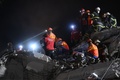 トルコ・イズミルで、倒壊した建物のがれきから生存者を捜索する救助隊員ら（2020年10月31日撮影）。(c)OZAN KOSE / AFP