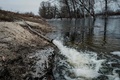 ウクライナ・ディミディウで1年前の洪水で湖のようになった沼地に排水するホース（2023年2月28日撮影）。(c)YASUYOSHI CHIBA / AFP