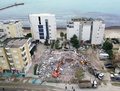 地震による被害を受けたアルバニア西部ドゥラスで、損壊した建物のがれきを撤去する重機（2019年12月2日撮影）。(c)Gent SHKULLAKU / AFP