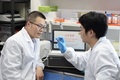 ＤＮＡストレージ用電極を確認する東南大学生物電子学国家重点実験室の劉宏教授（左）と学生（2021年11月29日撮影）。(c)Xinhua News