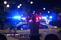 米首都ワシントンで、警察の規制線が敷かれた発砲事件の現場を携帯電話で撮影する男性（2021年7月22日撮影）。(c)Brendan SMIALOWSKI / AFP