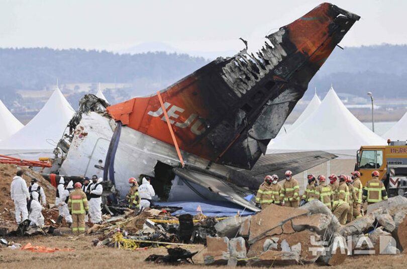 4日、務安国際空港で捜索を進める消防隊員(c)NEWSIS