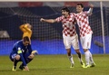 2014年サッカーW杯ブラジル大会（2014 World Cup）欧州予選プレーオフ第2戦、クロアチア対アイスランド。勝利を喜ぶクロアチアのヴェドラン・チョルルカ（Vedran Corluka、中央）、デヤン・ロブレン（Dejan Lovren、右）と落胆した様子を見せるアイスランドのギルフィ・シグルズソン（Gylfi Sigurdsson、2013年11月19日撮影）。(c)AFP/DIMITAR DILKOFF