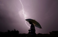 インド・ジャムで、雷雨のなか傘をさして歩く人（2015年5月15日撮影）。(c)rakesh bakshi / AFP