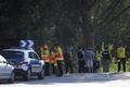 スペイン東部バルセロナ近郊で、ユネス・アブーヤアクーブ容疑者が射殺された現場に立つ警察官や医療関係者ら（2017年8月21日撮影）。(c)AFP/LLUIS GENE