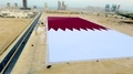 カタールで、建国記念日にあわせ、ギネス世界記録（Guinness World Records）を狙うために準備された巨大な同国の国旗（2013年12月15日撮影）。(c)AFP/KATARA MEDIA OFFICE