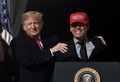 「アメリカを再び偉大に」と書かれた赤い帽子をかぶったワシントン・ナショナルズのカート・スズキ（中央）の肩に手をやるドナルド・トランプ大統領（2019年11月4日撮影）。(c)Olivier Douliery / AFP
