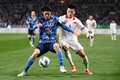 2022年サッカーW杯カタール大会アジア最終予選グループB、日本対ベトナム。相手選手とボールを競る山根視来（左、2022年3月29日撮影）。(c)Charly TRIBALLEAU / AFP
