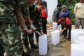 中国南西部・雲南（Yunnan）省Qujingで、軍の給水車から水をもらう村民（2010年3月28日撮影）。(c)AFP