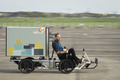 ドイツ・ベルリンで開催された自転車フェアで、カーゴバイクレースに参加する男性（2018年4月15日撮影）。(c)AFP PHOTO / Odd ANDERSEN