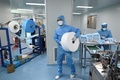 中国・北京の医療品メーカーで、防護服を着てマスク製造に当たる従業員ら（2020年4月24日撮影、資料写真）。(c)WANG ZHAO / AFP