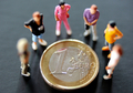 1ユーロ硬貨を取り囲む人形（2012年8月24日撮影、資料写真）。(c)AFP/PHILIPPE HUGUEN