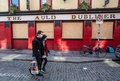 アイルランド・ダブリンにある一時休業中のパブの前を通るマスク姿の人たち（2020年3月25日撮影）。(c)PAUL FAITH / AFP