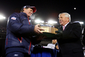 チームオーナーのロバート・クラフト（%%Robert Kraft%%）氏（右）からラマー・ハント・トロフィー（Lamar Hunt Trophy）を手渡されるペイトリオッツのビル・ベリチックヘッドコーチ。(c)AFP/Getty Images/Elsa
